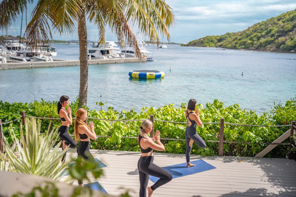 a group of women doing yoga on a deck overlooking the Caribbean