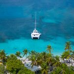 a sailing catamaran anchored off a Caribbean island